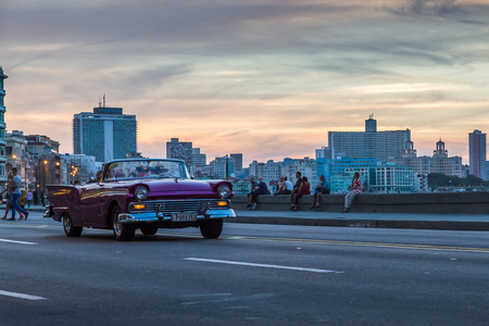 Classical convertible giving tourists an experience they'll never forget - a sunset trip down the Malecon with the top down.のeditorial素材