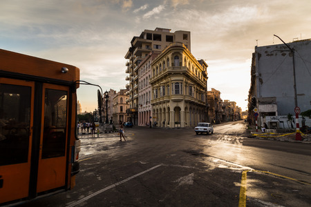 An orange bus crosses the Prado in Havana (road separating the Old Town area with Centro Havana) just before dusk in the Cuban capital.のeditorial素材