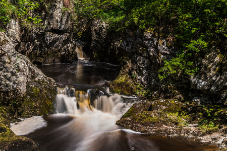 Water flows out of a circular pool at the Snowfalls cascade along the Ingleton waterfalls trail in North Yorkshire - captured as a long exposure with a ten stop ND filter.の写真素材