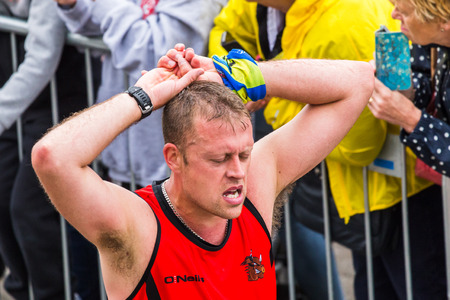 A half marathon runner crosses the finishing line by the Liverpool Echo arena on 28 May 2017 having ran in the 2017 Liverpool Rock n Roll marathon.のeditorial素材