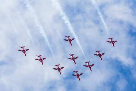 The Red Arrows descend from a loop as they fly in Nine Arrow formation after arriving at the Blackpool airshow.のeditorial素材