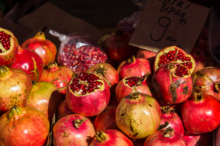 Pomegranate seeds sparkle in the autumn sunshine as they sit piled up on a market stall on Split's green market.の写真素材