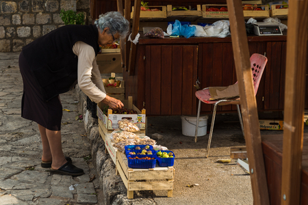 A senior woman attends to her fruit and nut stall on the side of the street in Ston, a coastal town in Croatia which links the Peljesac peninsula with the mainland.のeditorial素材