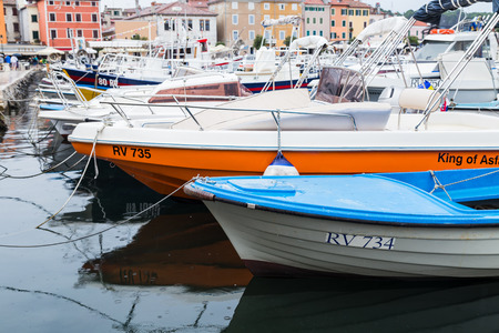 Differing colours and sizes of fishing boats moored to the quayside in Rovinj harbour captured in September 2019.のeditorial素材