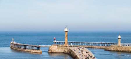 Multiple image panorama of tourists on the West pier of Whitby harbour one afternoon in September 2020.の写真素材
