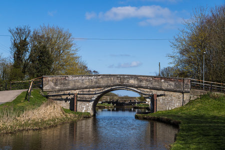 Looking under a road bridge towards a lock on the Rufford branch the Leeds Liverpool Canal near Burscough, Lancashire in April 2021.の写真素材