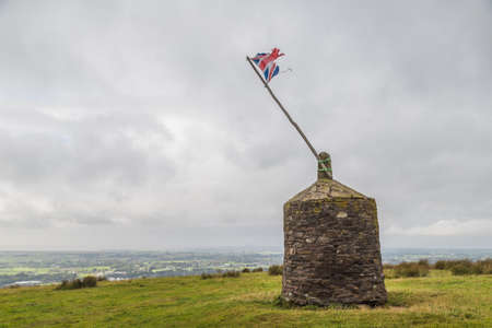 A battered Union Jack flag pictured on top of a Cairn in Garstang, Lancashire in September 2021.  It was originally built for the Golden Jubilee of Queen Victoria and was repaired for the Silver Jubilee of Queen Elizabeth II.の写真素材