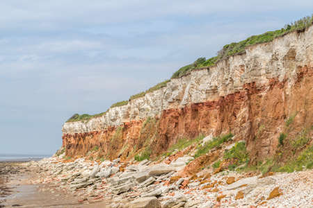 Hunstanton cliffs at low tide seen in the summer of 2021 featuring the stripy coloured rocks falling...