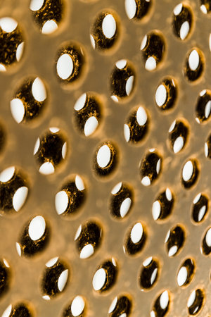 Close up of golden coloured exterior metal covered in small holes.の写真素材