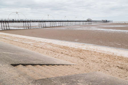 Steps lead down from the promenade to the sandy beach at Southport captured in March 2021 during the Covid pandemic.の写真素材