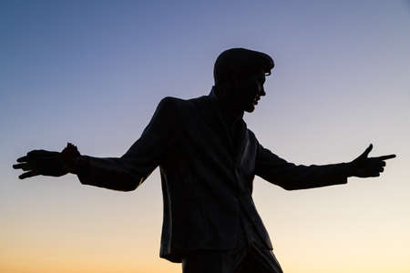 Billy Fury statue on the Liverpool waterfront silhouetted against the setting sun seen in August 2021.のeditorial素材