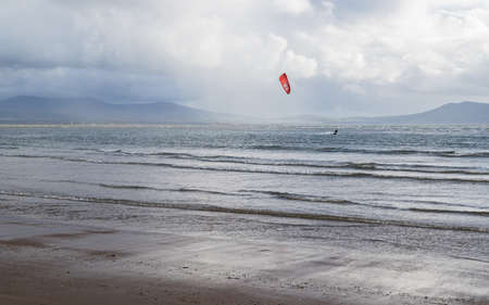 A lone kite surfer enjoying the windy condidions on the Anglesey coast in North Wales seen in...