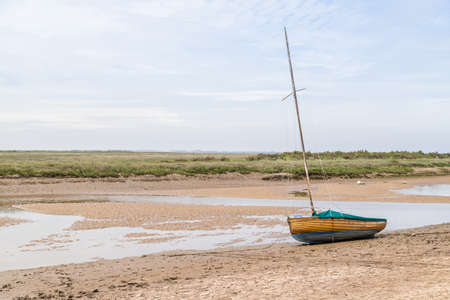 Sailing boat beached at low tide at Blakeney on the North Norfolk coast captured in June 2021.