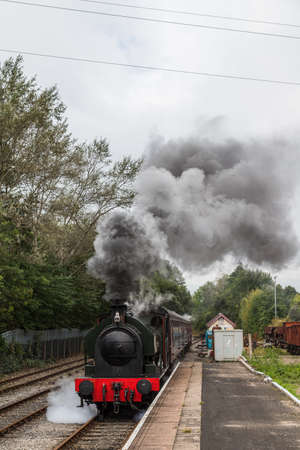 A Steam train approaching a platform on the Ribble Steam Railway at Preston, Lancashire in September 2021.のeditorial素材
