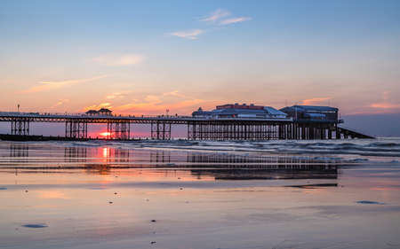 The sun sets behind the pier at Cromer on the North Norfolk coast during June 2021.のeditorial素材