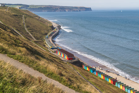 Beach huts on the Whitby seafront seen at the foot of the winding pathways in September 2020.のeditorial素材
