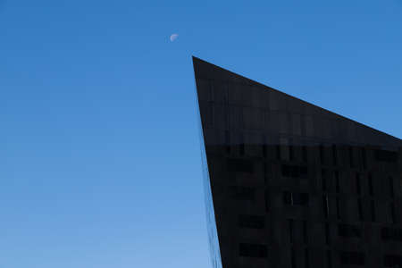 The pointed edge of a building on the Mann Island complex point towards the moon in Liverpool in...