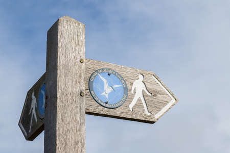 A sign post seen along the Anglesey Coastal Path in North Wales under a clear sky.のeditorial素材