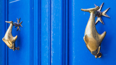 Dolphin door knockers pictured on a blue door in Mdina in the heart of Malta in April 2022.の写真素材
