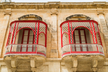 Looking up at a pair of pretty red balconies in Mdina, the old capital city of Malta seen in April 2022.のeditorial素材