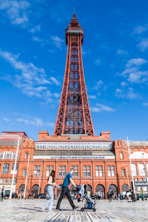 A young family seen walking passed Blackpool Tower on the Comedy Carpet in September 2021.のeditorial素材
