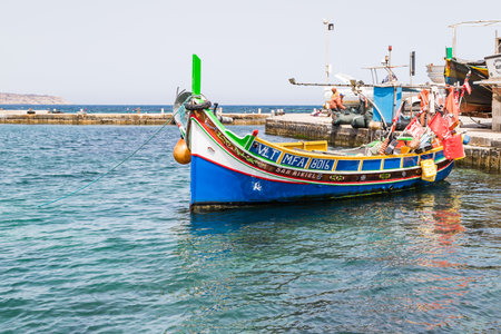 Luzzu boat at Mellieha harbour seen on the clear waters of the Mediterranean in May 2022 whilst in Malta.のeditorial素材