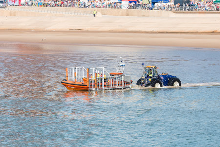 Life boat being launched from its semi submersible tractor off Blackpool beach in August 2022.のeditorial素材