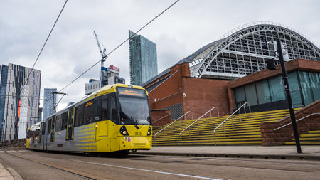 Yellow tram passing the Manchester Central Convention Complex captured in February 2023.のeditorial素材