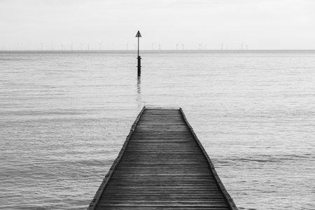 Wooden slipway off  Llandudno beach stretching out into the sea at low tide.の写真素材
