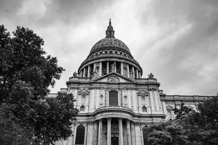 A black and white image looking up at the iconic St Pauls cathedral whose dome can be seen across the city of London, seen in July 2022.の写真素材