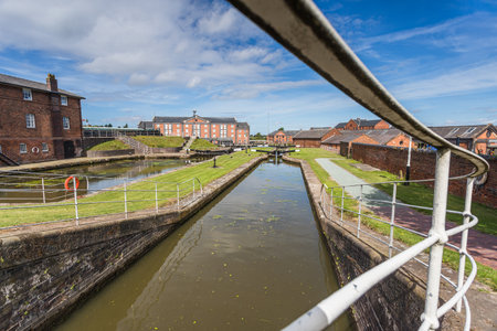 Looking along the railings which enclose one of the canal locks at Ellesmere Port, Cheshire seen in August 2022.の写真素材