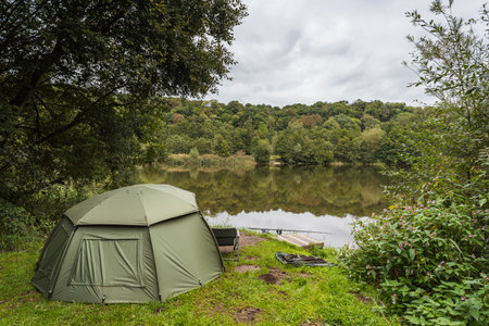 Image of an angler fishing from his bivy tent on the waters edge near Preston in September 2022.の写真素材