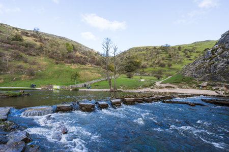 Tourists seen exploring Dovedale around the wet stepping stones in November 2021 after heavy rainfall partially flooded the valley.の写真素材