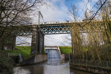 A train passes over a high bridge over the flowing the Carr Mill Dam near St Helens, Merseyside on 3...
