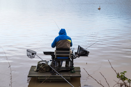 A lone fisherman seen fishing from a platform on the edge of Carr Mill Dam near St Helens, Merseyside on 3 January 2022.の写真素材