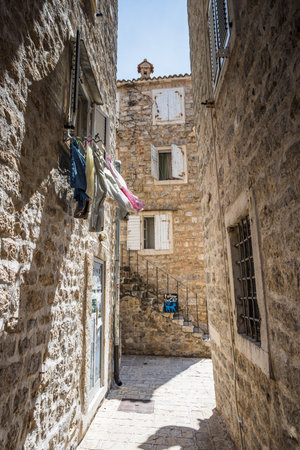 A follow the cat sign in the old town of Budva pictured in May 2023 at the foot of some steps and under some hanging laundry.の写真素材