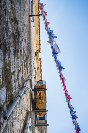 Looking up at a full line of laundry hanging out to dry in the old town part of Budva, Montenegro in May 2023.の写真素材