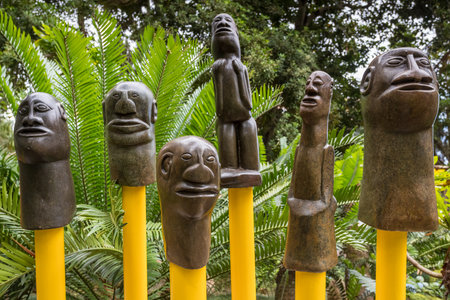 Close up of sculptures on yellow poles seen in Monte Palace Gardens near Funchal, Madeira on 31 July 2024 against a lush green background.の写真素材