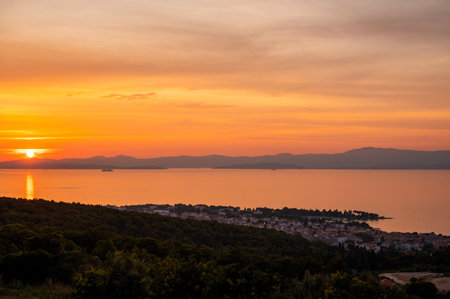 Orange and golden sky during sunset over Supetar city in Croatia. Spectacular panorama on city...
