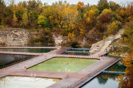 Swimming pool on the bank of the river in the autumn forestの写真素材