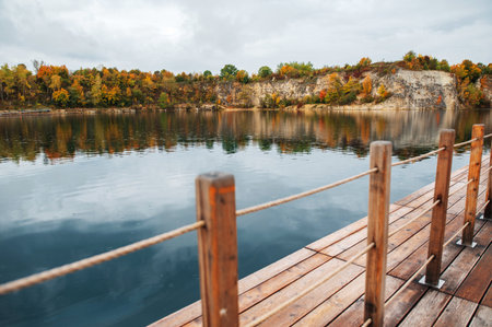 Wooden pier on the lake with autumn forest in the background.の写真素材