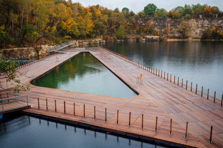 Wooden bridge over the lake in the autumn forest, natural landscapeの写真素材