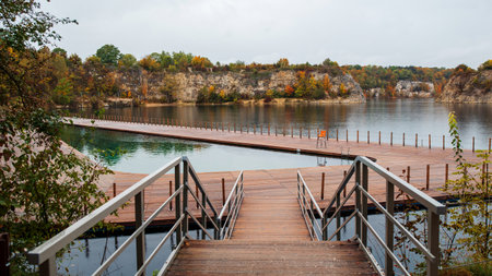 Wooden pier on the lake. Beautiful autumn landscape in the park.の写真素材