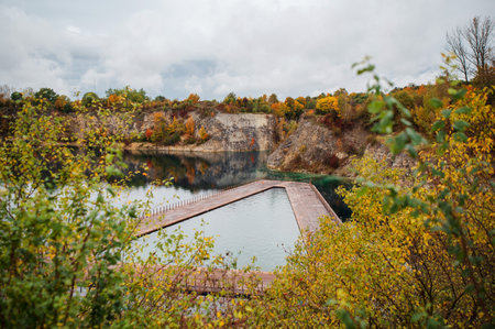 A wooden bridge over a lake in the middle of the forest.の写真素材