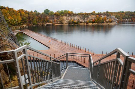 Wooden walkway to the lake in autumn. Beautiful landscape.