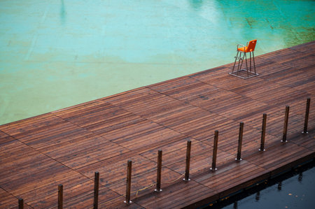 Swimming pool with orange chair and blue water in the background.の写真素材