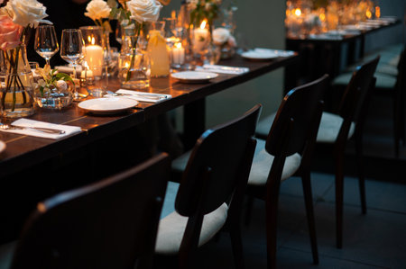 Elegant dining table setup with candles and flowers in a dimly lit restaurant.の写真素材