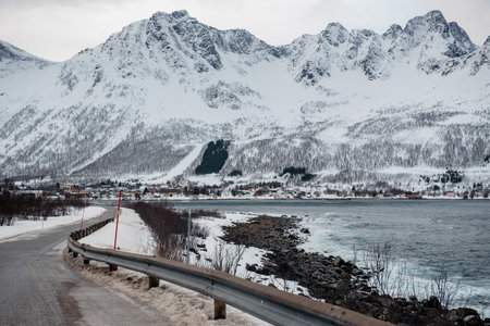 Snow-covered mountains and a coastal road in a winter landscape. Lofoten islands, Norway