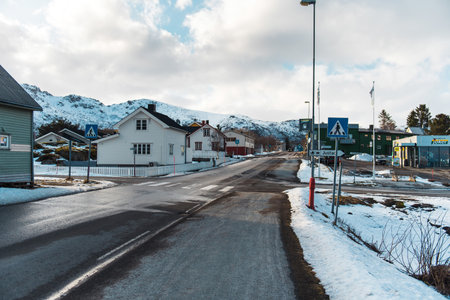 Snowy village street with houses and mountains in the background. Lofoten islands, Norwayの写真素材