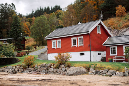 Traditional Red Norway wooden house in a rural autumn landscape with treesの写真素材